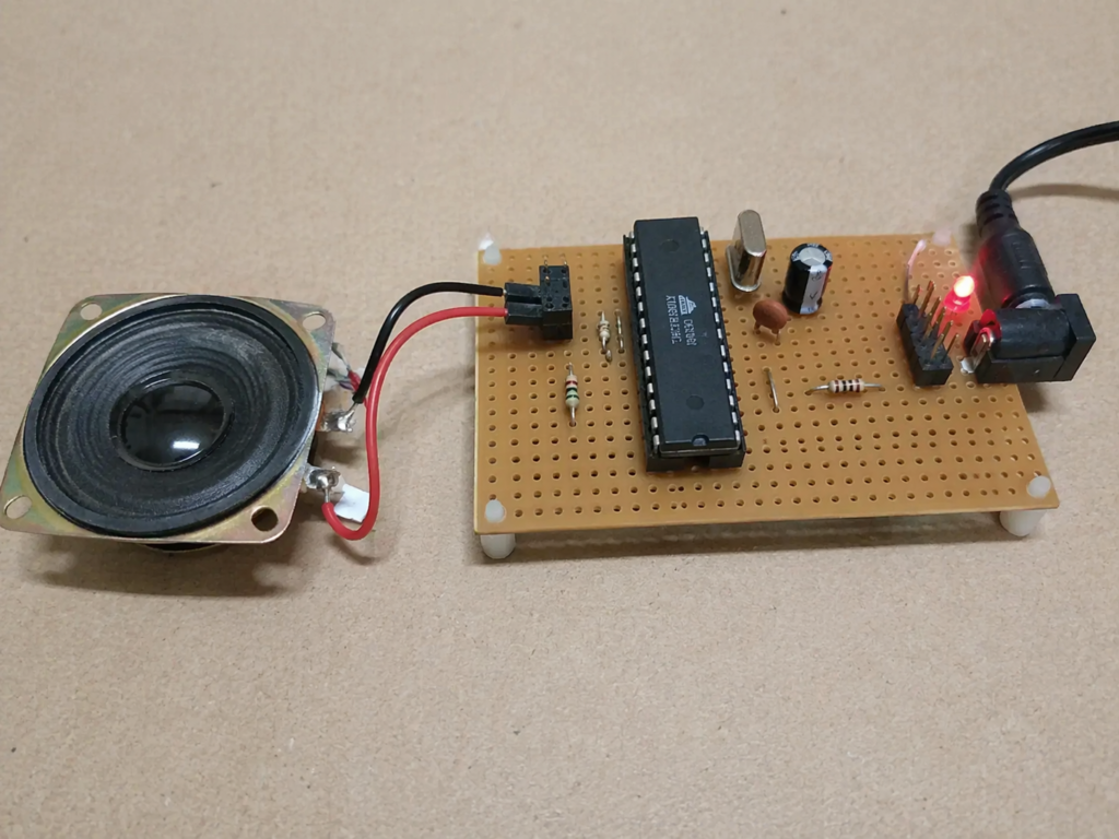 ATmega8 melody player prototype with speaker and perfboard.